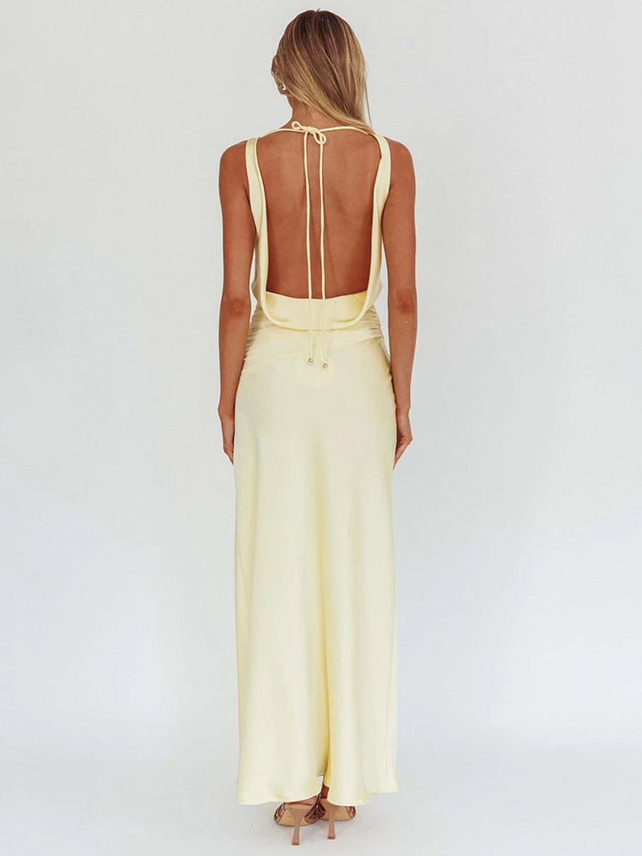 Back view of light yellow satin maxi dress with open-back straps and draped bodice