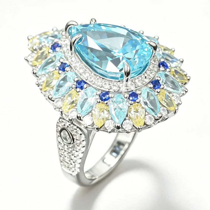 Silver cocktail ring with oval aquamarine center and blue, yellow cluster halo