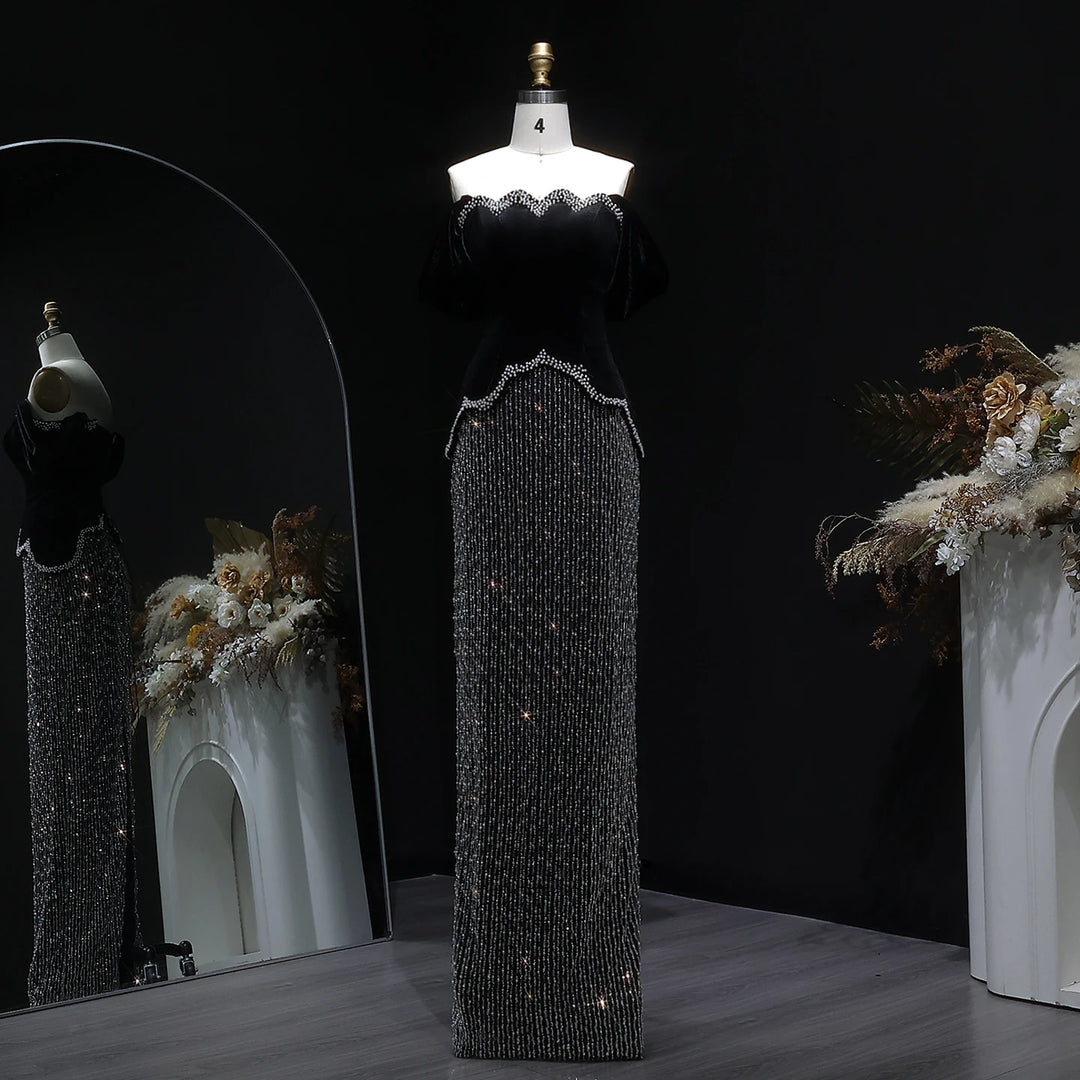 Mannequin wearing a black beaded dress with floral decorations against a dark background