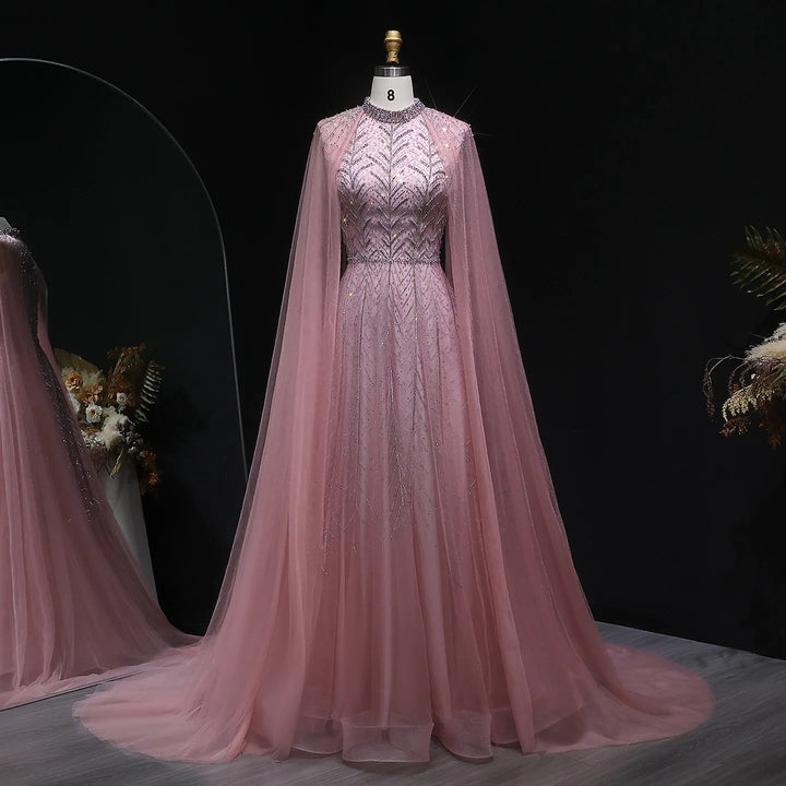 Pink evening gown with cape on a mannequin against a dark background