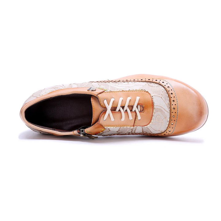 Light khaki lace-up low-heel shoes with floral upper, tan toe cap, side view close-up.