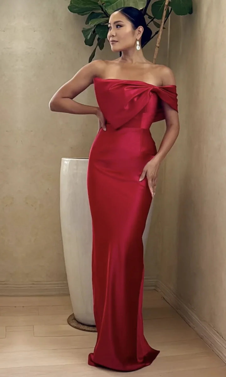 Red floor-length prom gown with strapless draped bust and bow detail, fitted skirt