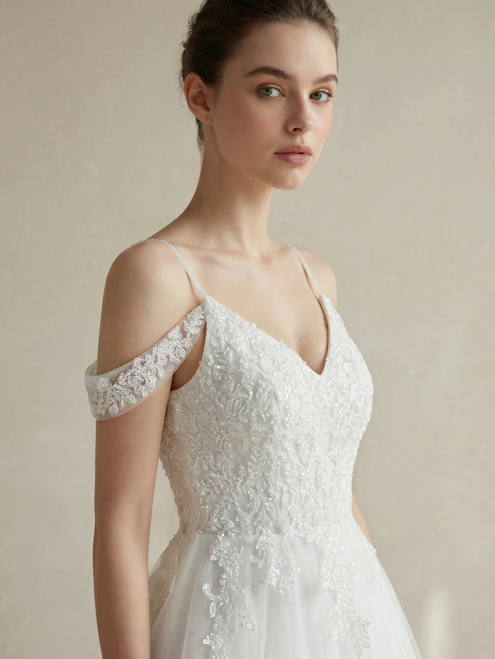 White bridal gown close-up with beaded bodice and off-shoulder lace sleeves
