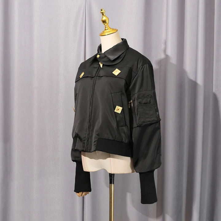 Black cropped coat on mannequin with zip front, stand collar, gold buttons and side pockets.