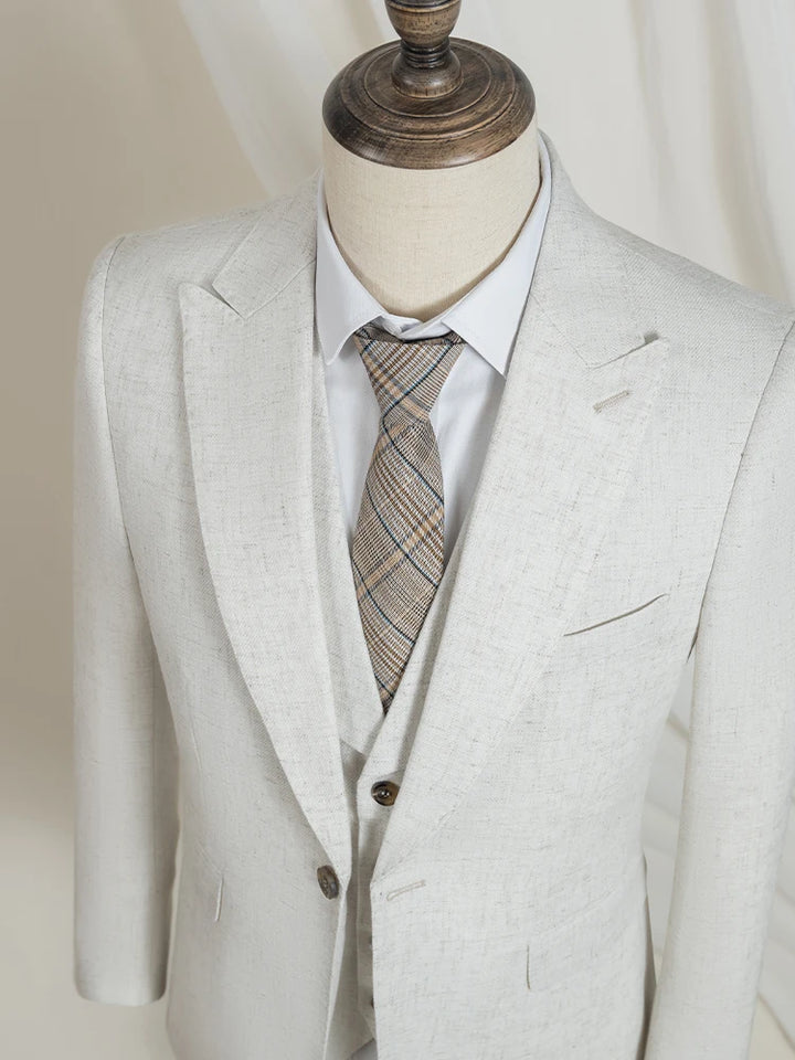 Light beige formal suit jacket and vest on mannequin with patterned necktie