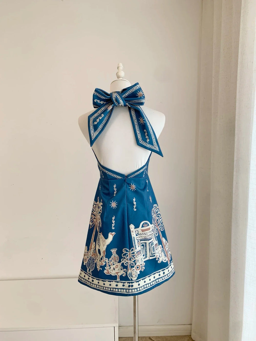 Blue halter neck mini dress with ornate gold-and-white border print