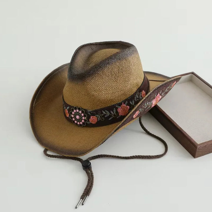 Embroidered cowboy sun hat, olive-brown straw with dark band and pink floral embroidery, tie