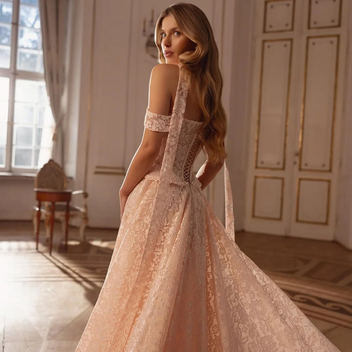 Champagne lace off-shoulder wedding gown, back/side view with long flowing skirt