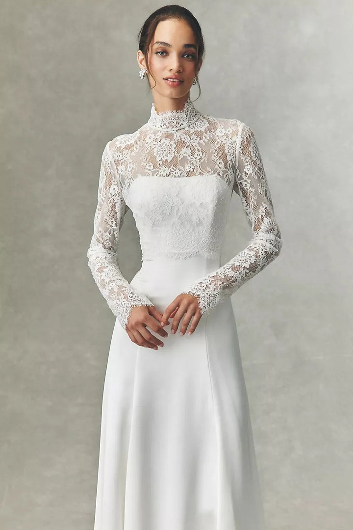 White lace high-neck bridal jacket with long sleeves, front view over satin skirt