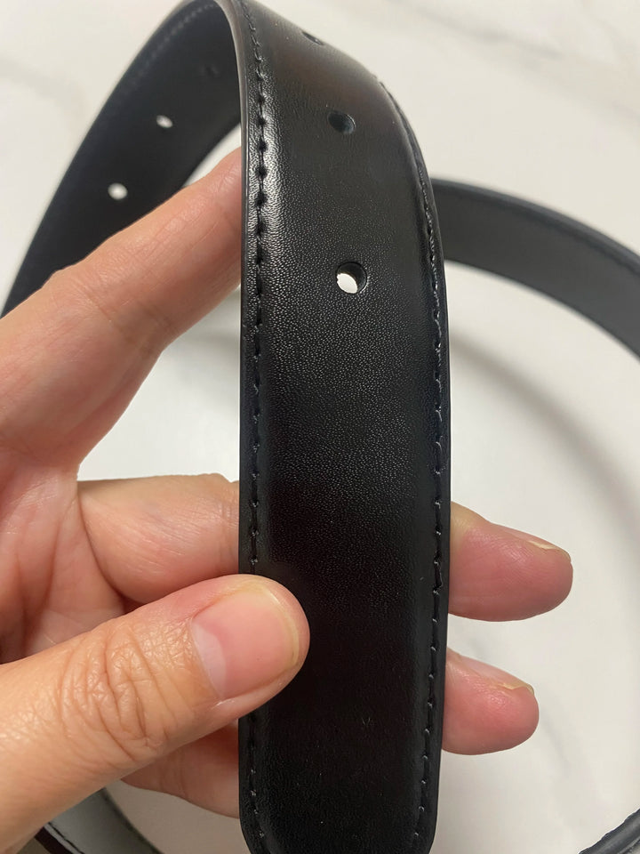 Black leather belt strap with punched holes and stitched edge, no buckle shown