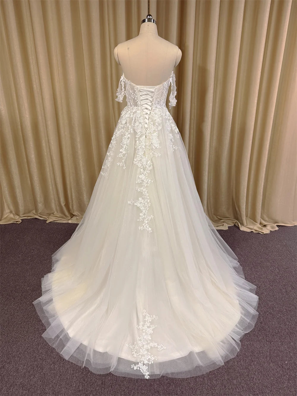 Off-shoulder ivory lace bridal gown with lace-up back and long tulle train