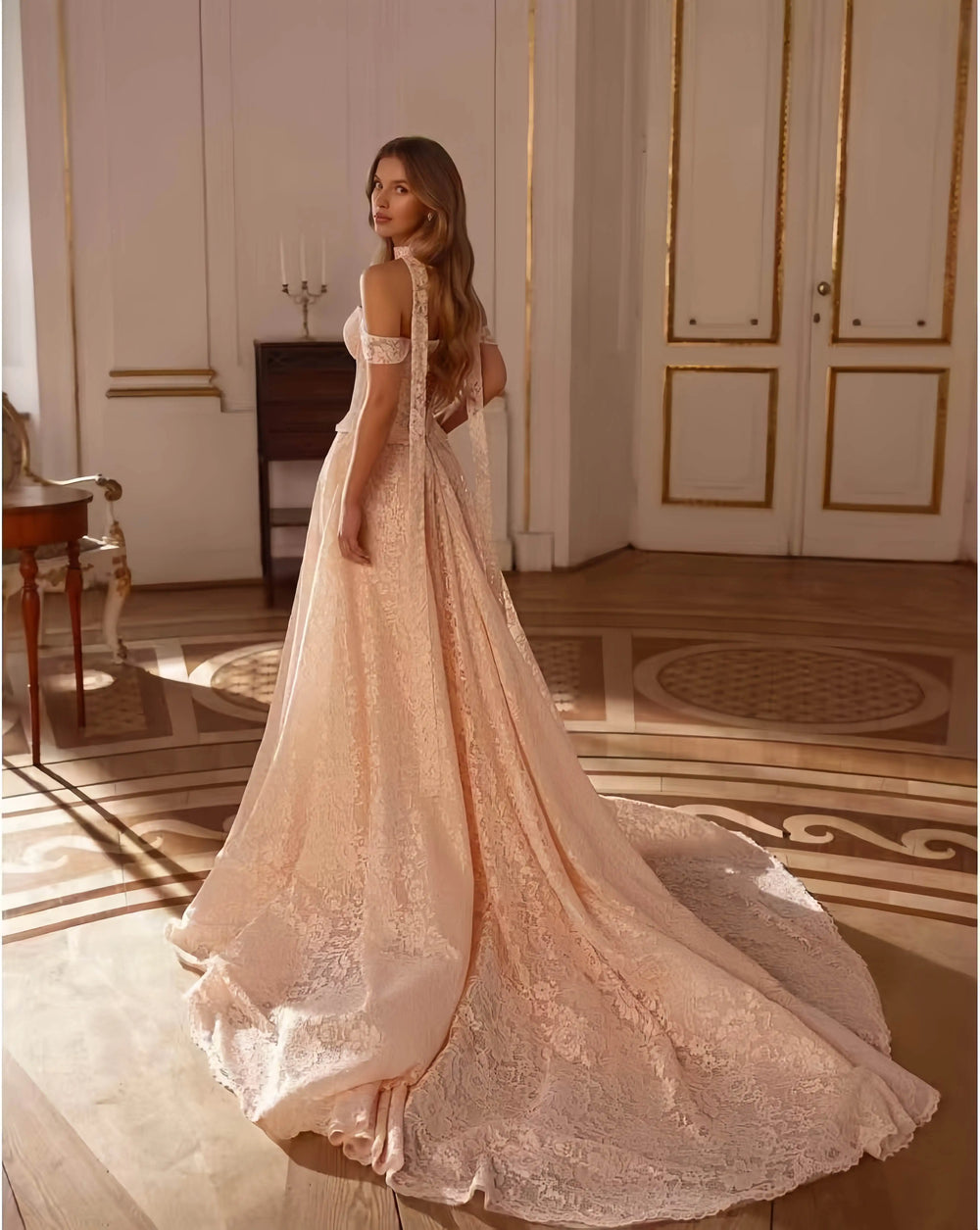 Champagne beige lace bridal dress with long sleeves, fitted bodice, and full flowing skirt