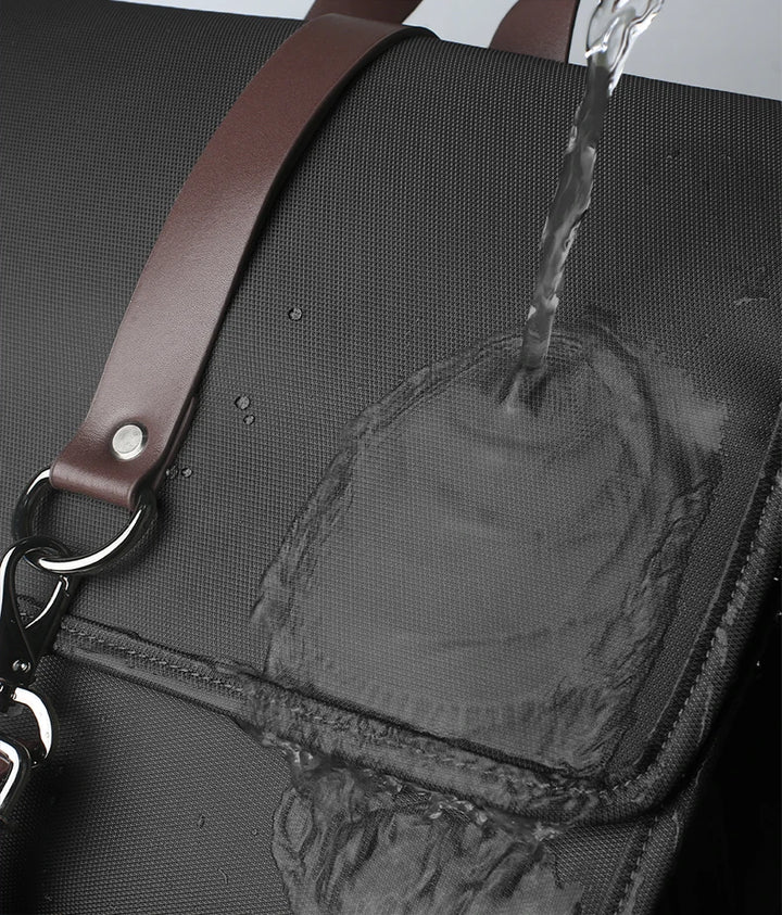 Close-up of waterproof fabric backpack with brown leather-style trim and keyring