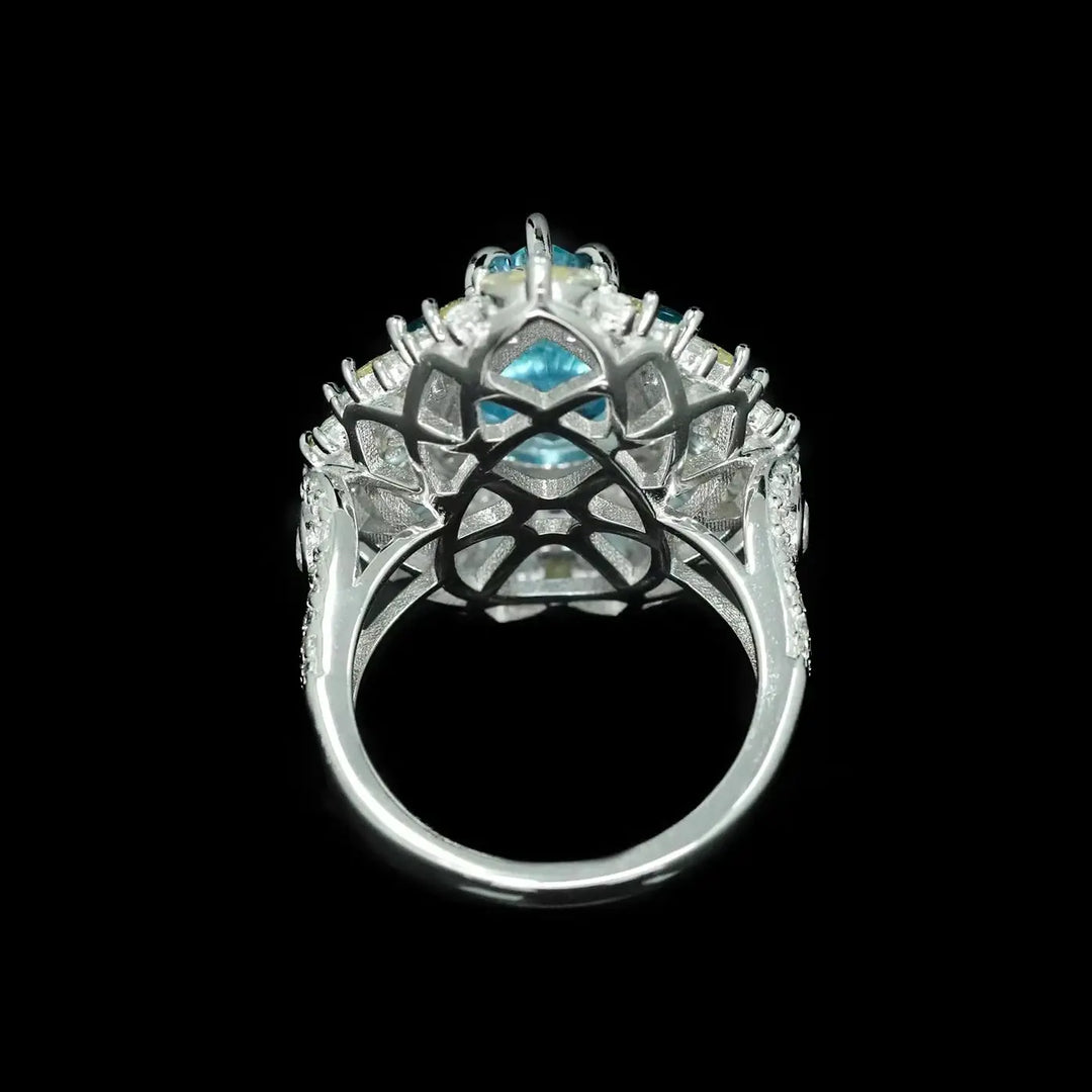 Silver openwork halo ring with aquamarine center stone and blue side accents