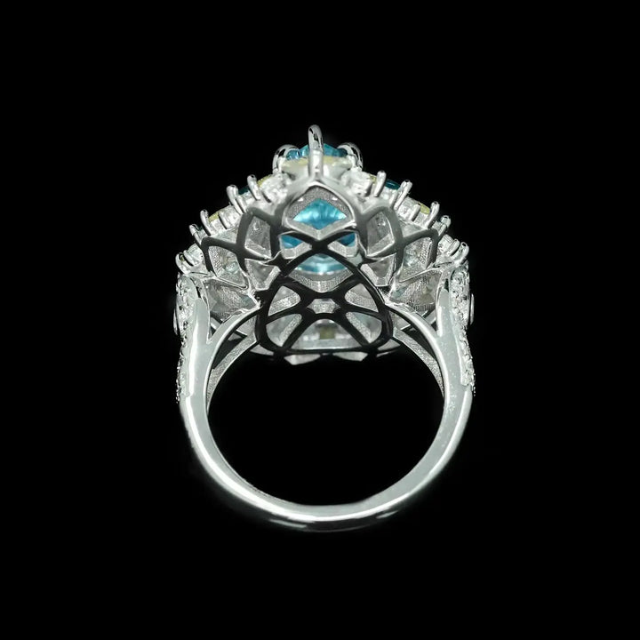 Silver openwork halo ring with aquamarine center stone and blue side accents
