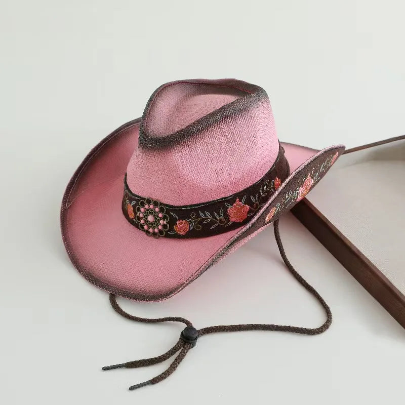 Rose pink cowboy hat with black embroidered band, floral details, and chin ties
