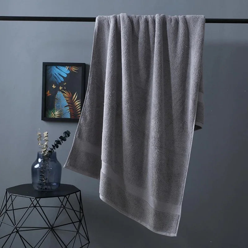 Bath towel in grey, neatly hanging with textured terry surface and straight edge