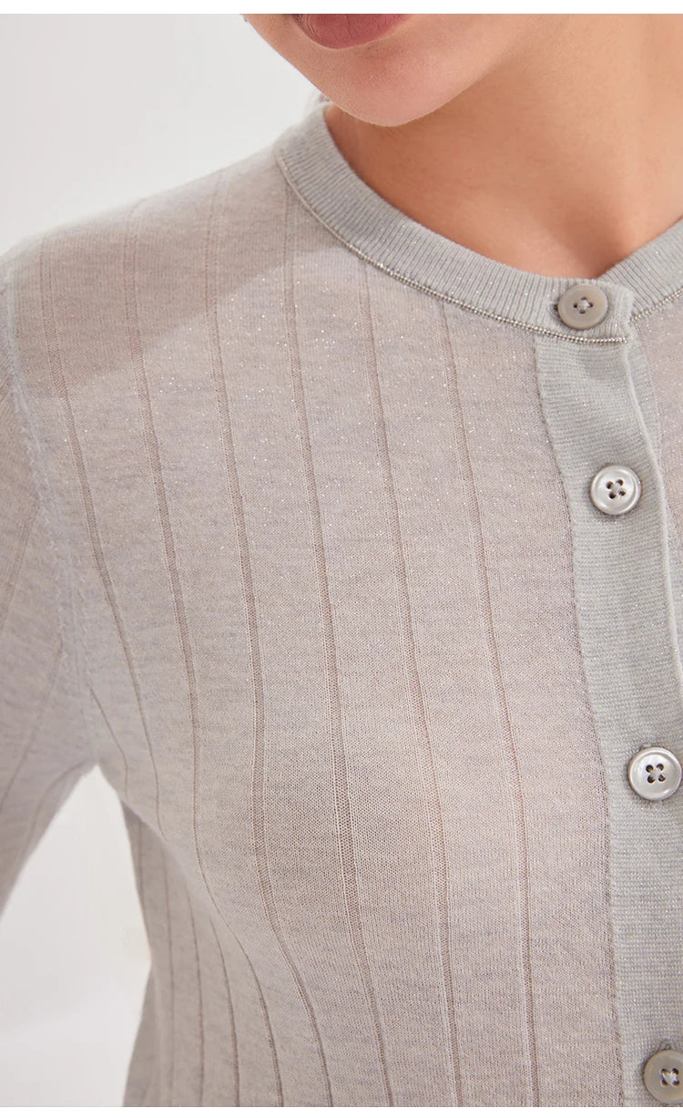 Close-up of a ribbed knit cardigan with button details on a light background