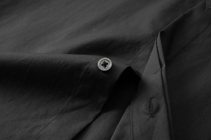 Black men’s slim-fit shirt close-up of button placket with one visible button