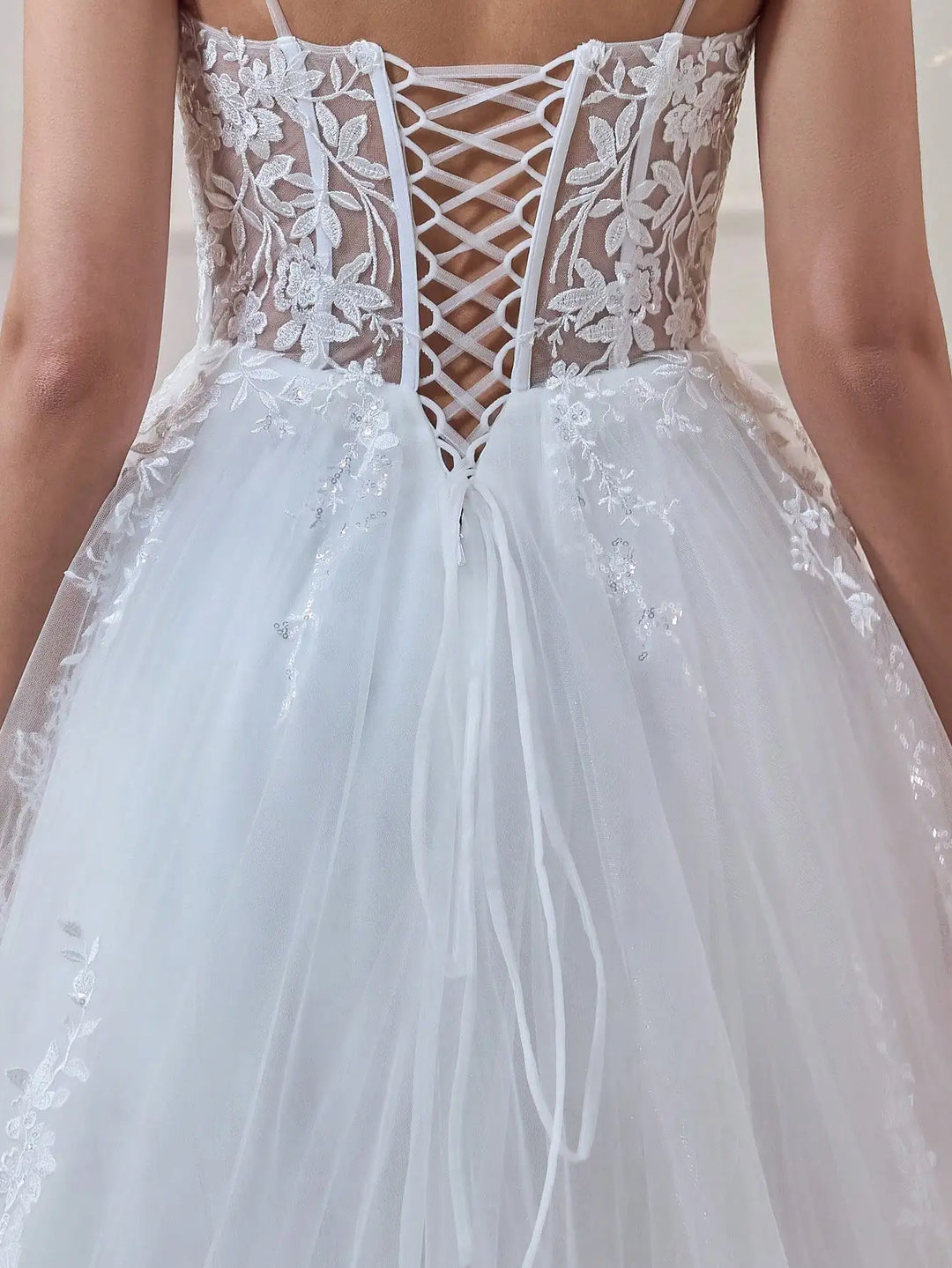 White tulle bridal gown with deep V lace-up bodice and floral applique skirt