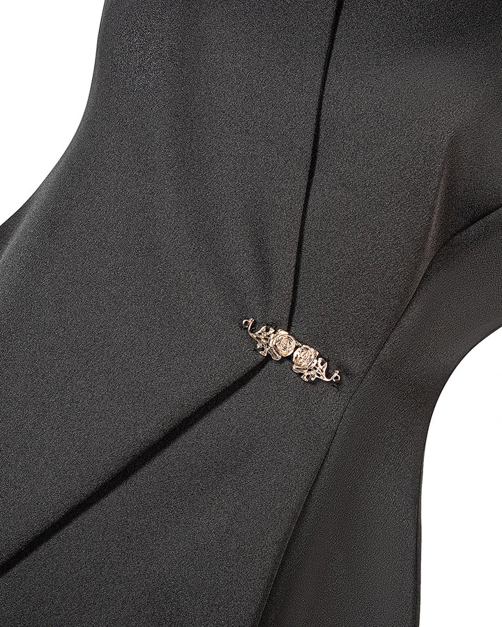 Close-up of gold-toned clasp detail on black peplum vest front overlay