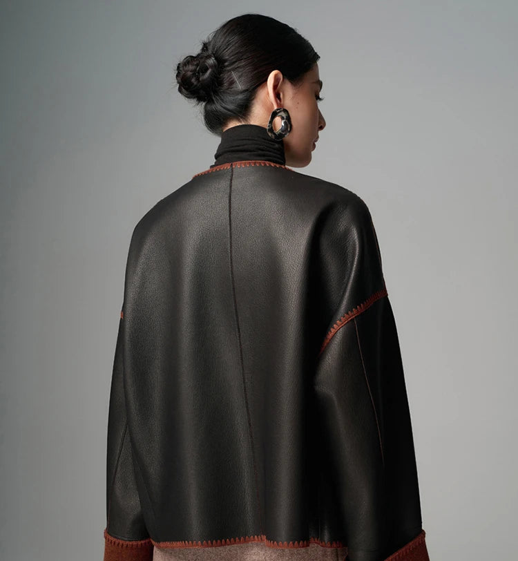Women’s black goatskin short leather jacket, back view with brown trim and orange stitching