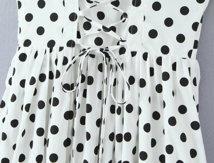 White polka-dot midi dress front with gathered waist and bow-style tie detail