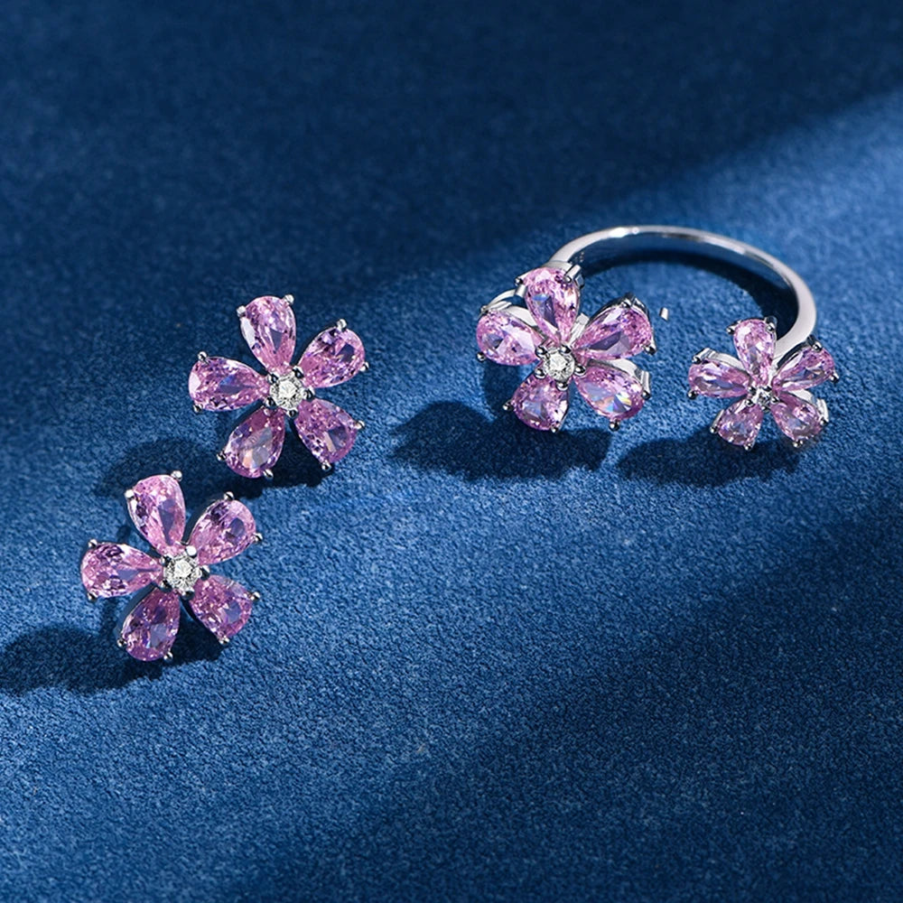 Pink flower stud earrings with six teardrop stones, silver-tone settings on dark base
