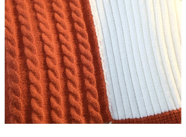 Orange and white cable-knit patchwork sweater panel detail