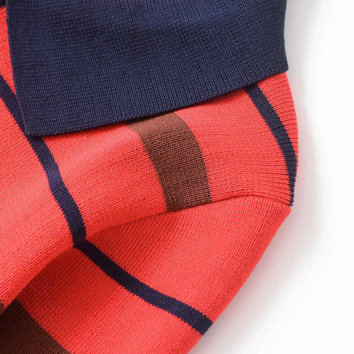Ribbed cuff detail on orange-red striped polo sweater with navy and brown stripes
