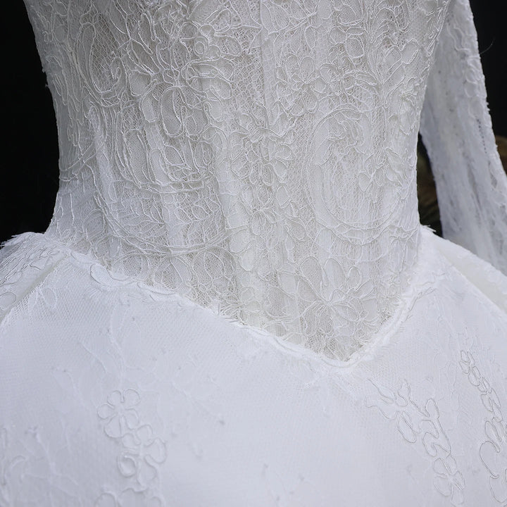 White lace high-neck wedding gown bodice detail with floral lace texture