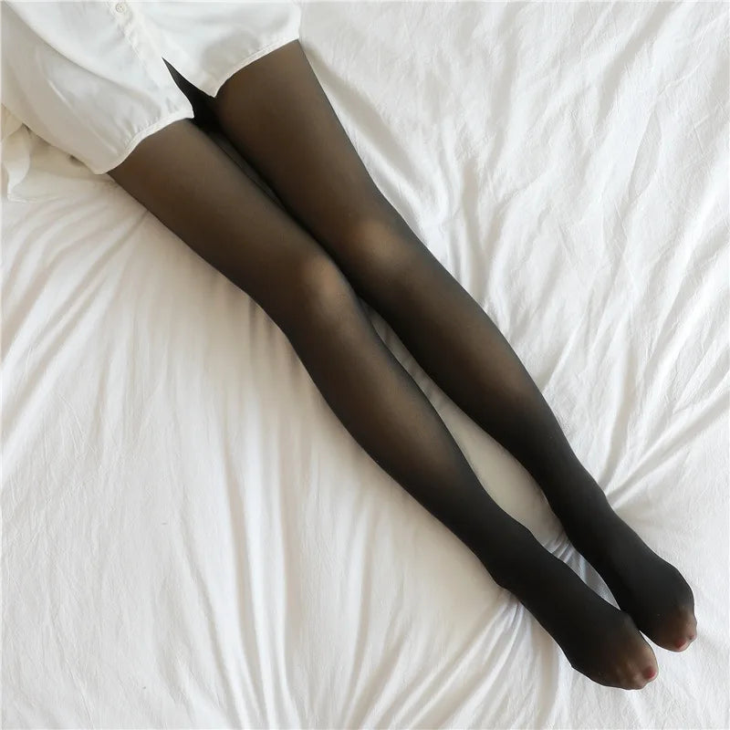 Sheer dark fishnet stockings, close view of thighs and calves on white bedding.