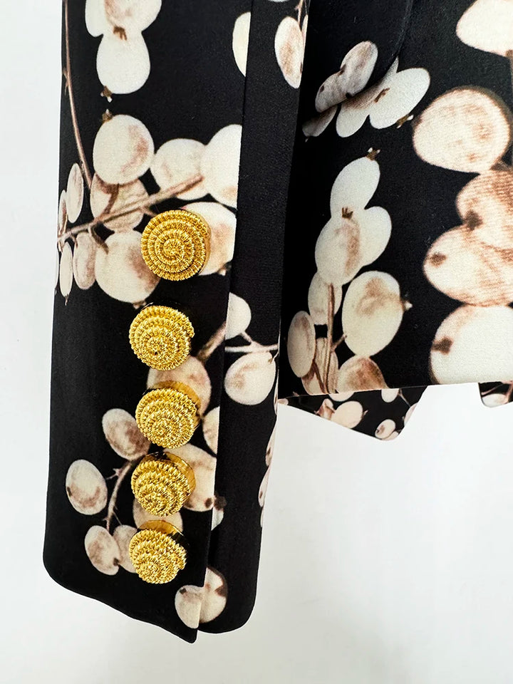Black blazer jacket sleeve cuff with four gold round buttons and cream oval print
