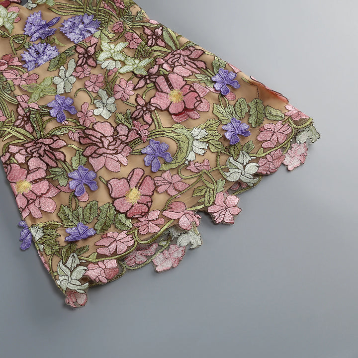 Floral embroidered mini gown hem close-up with multicolor flower and leaf appliques