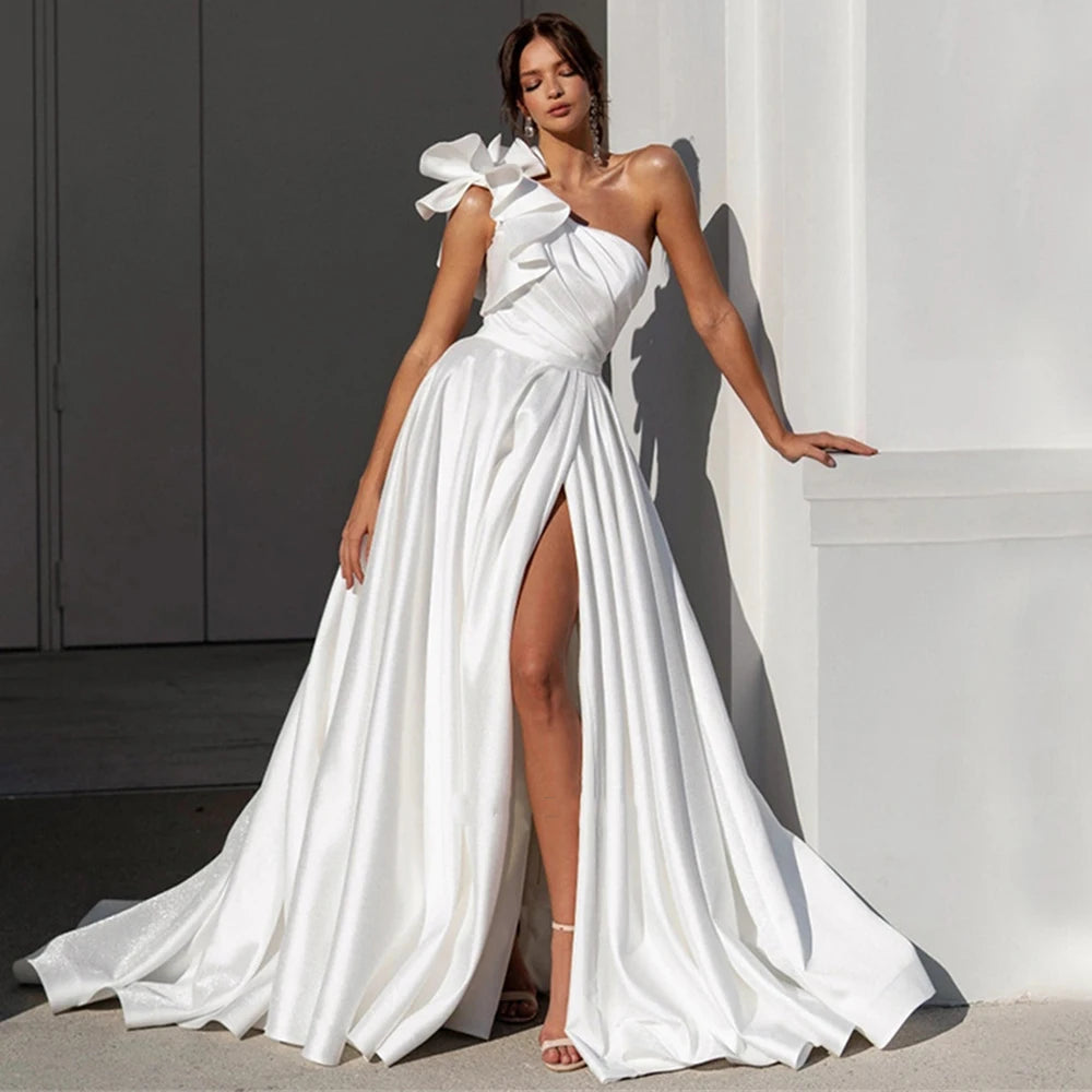 White satin wedding dress with one-shoulder bow and high slit, draped skirt