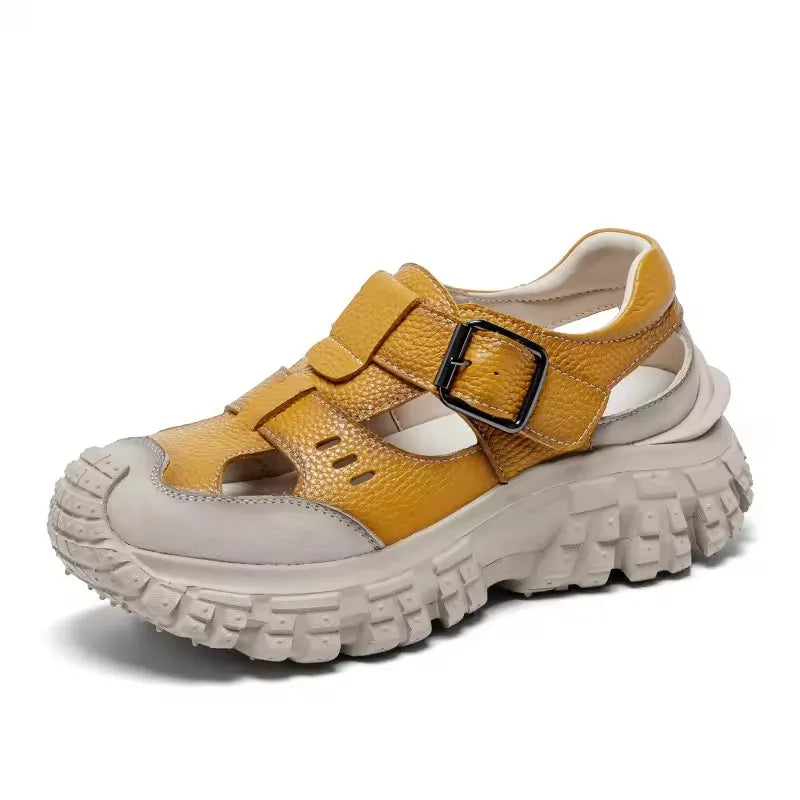 Yellow chunky leather sandals with two straps and black buckle, thick tread sole