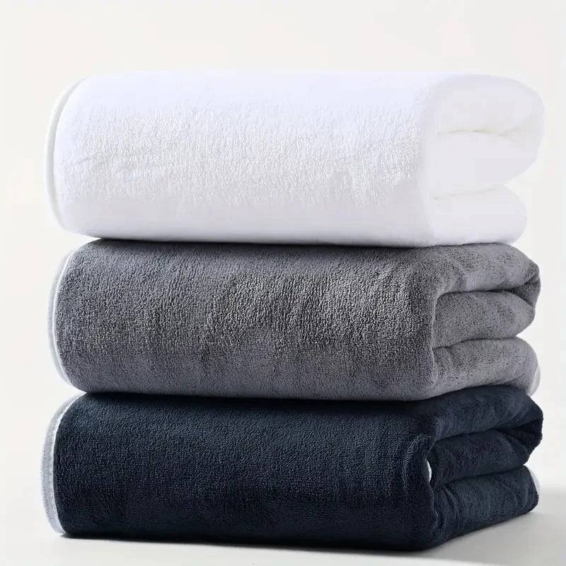 Plush velvet bath towel set in white, gray, and dark navy, folded and stacked.