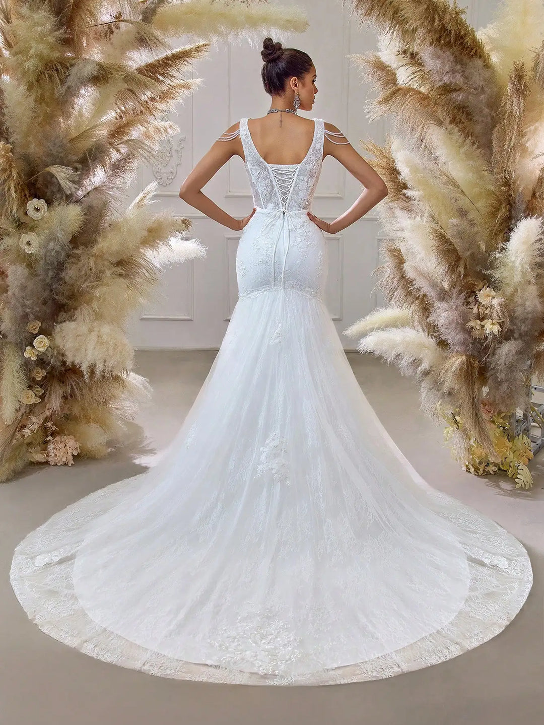 White beaded bridal mesh gown with open-back illusion yoke and flowing mermaid train
