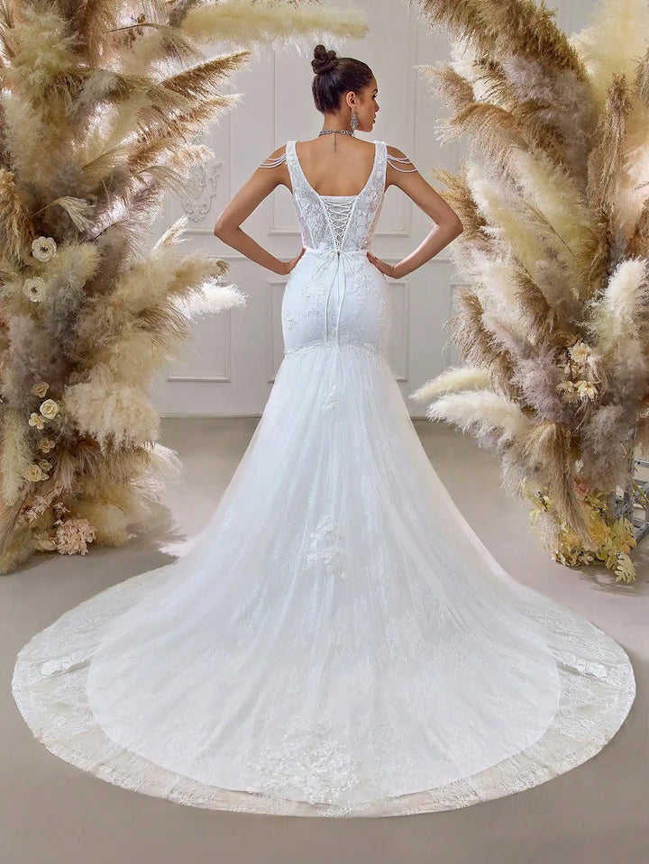 White beaded bridal mesh gown with open-back illusion yoke and flowing mermaid train