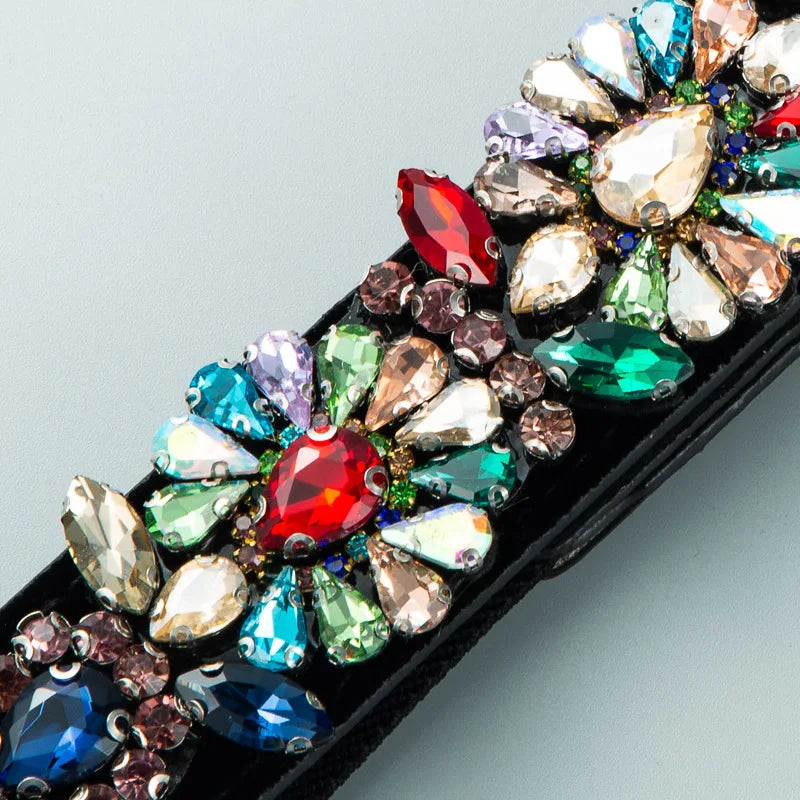 Close-up rhinestone trim with multicolor faceted stones on black belt