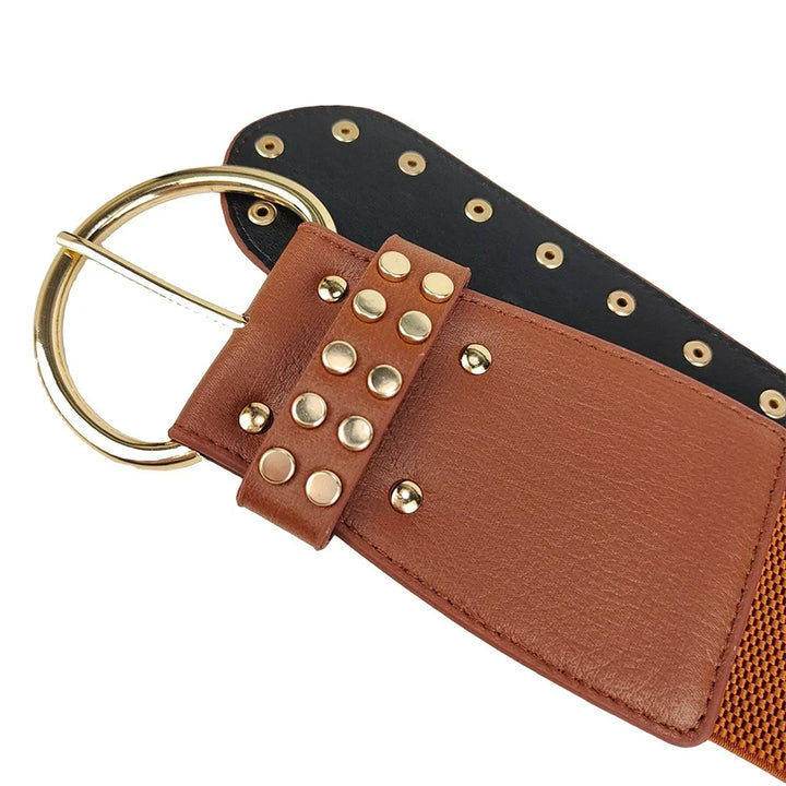 Studded leather belt in tan with black end panel and gold O-ring buckle, rivets.