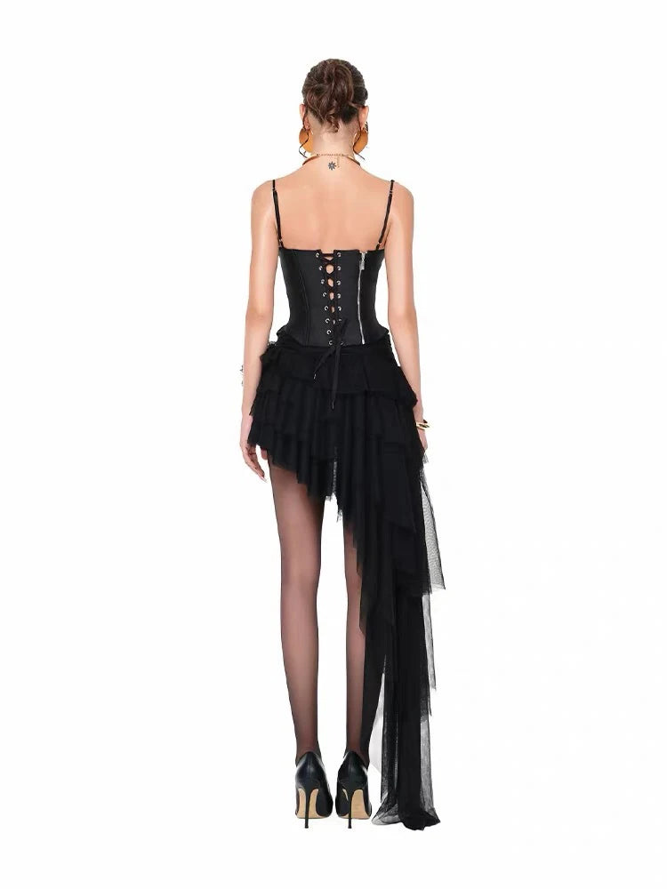 Back view of black corset-style top and asymmetrical ruffle skirt with draped train