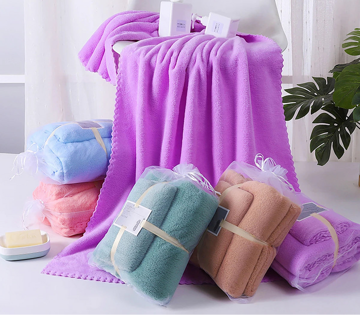 Plush bath towel set in purple, several folded towels stacked and tied