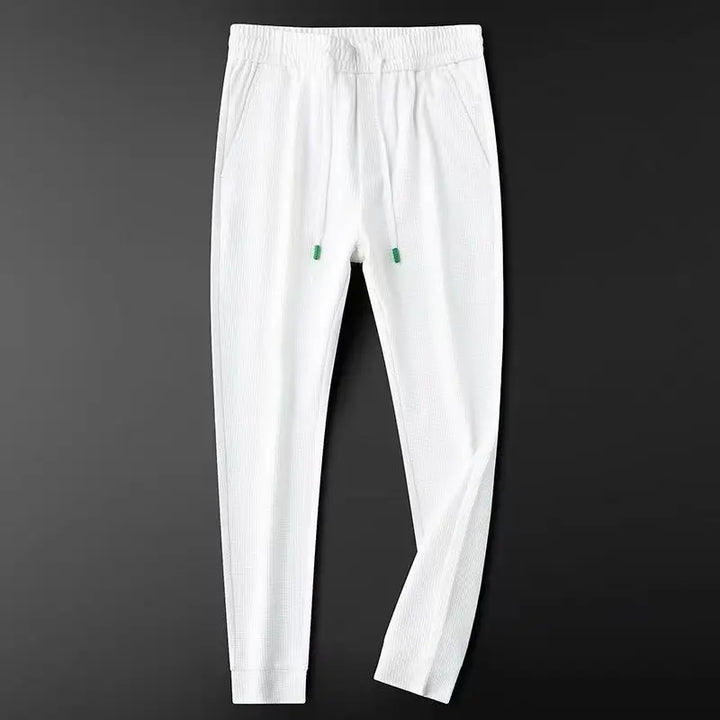 White relaxed slim cotton track pants with elastic waist and drawstring, ankle cuff