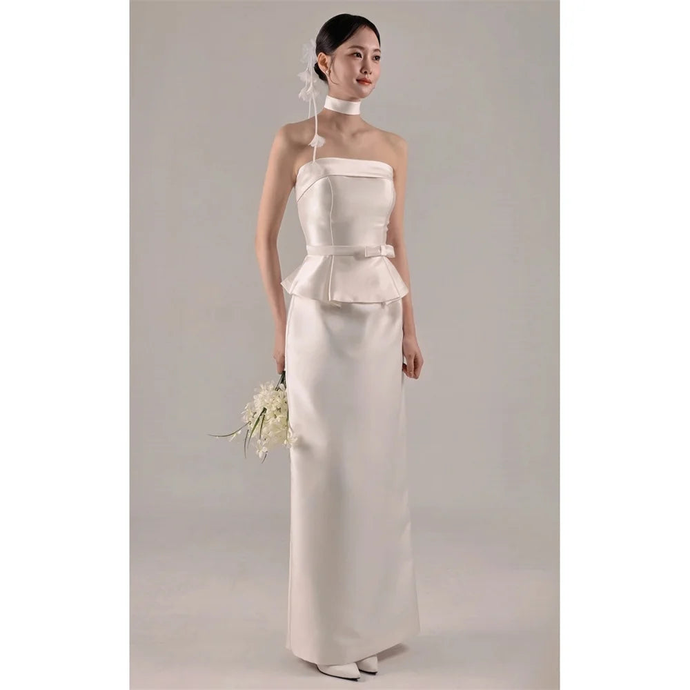 White strapless satin wedding dress with peplum waist and long fitted skirt