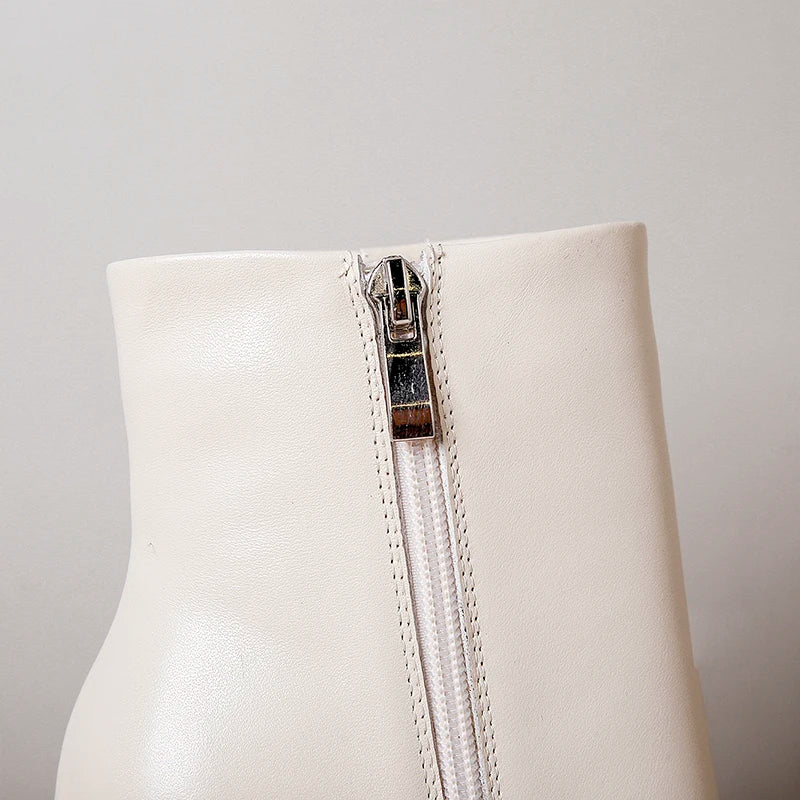 Cream leather ankle boot with visible side zipper and stitched trim