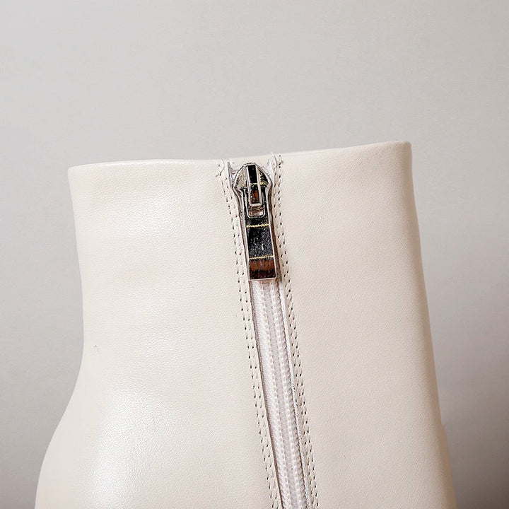 Cream leather ankle boot with visible side zipper and stitched trim