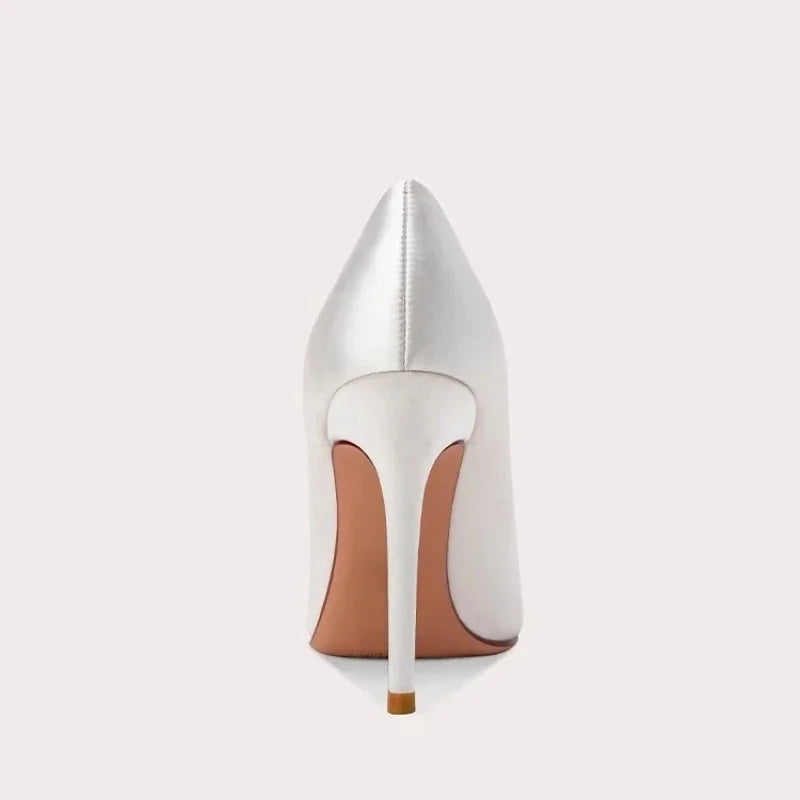 White satin slip-on pumps with pointed toe and gold stiletto heel, rear view