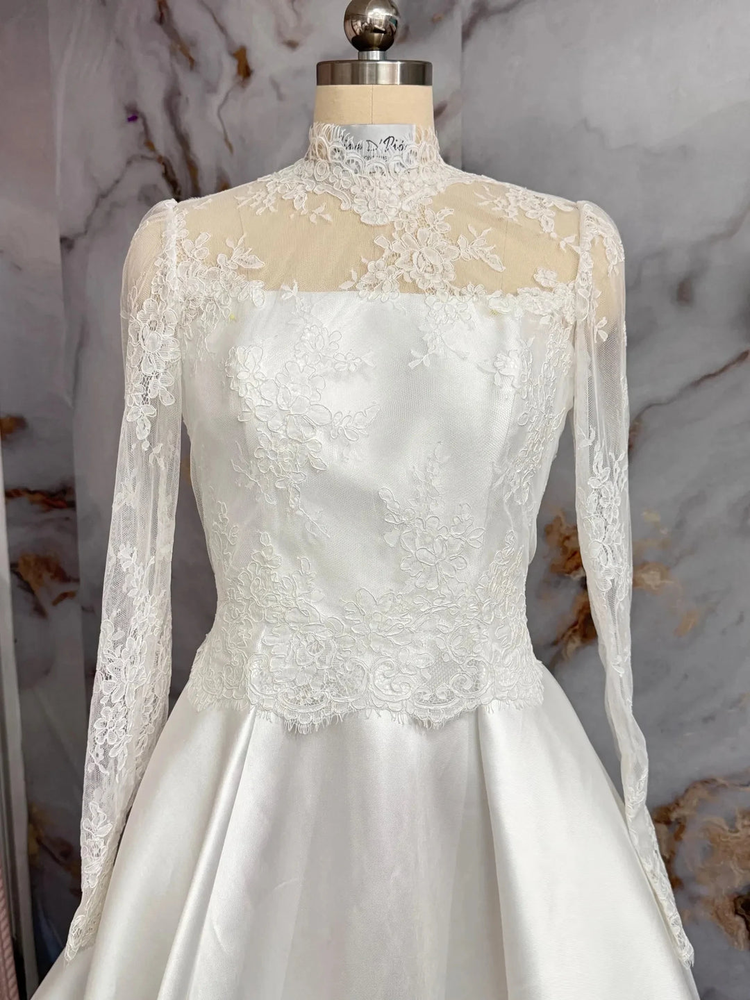 Off-white lace bridal jacket with high neck, fitted lace bodice and long sheer sleeves