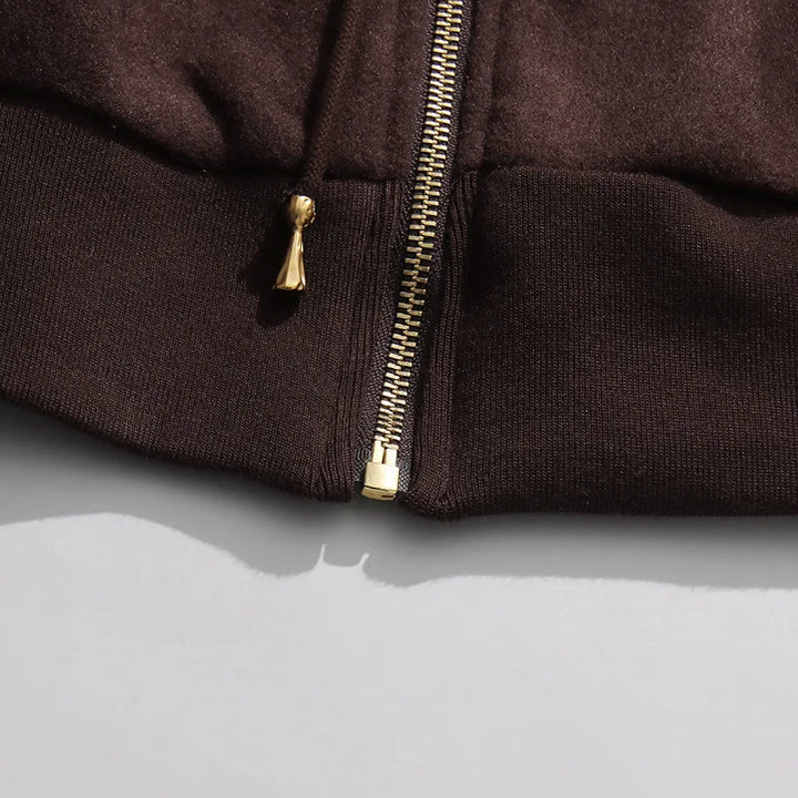 Coffee brown pants close-up of zipper fly with gold-toned pull tab